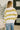 Person wearing a striped sweater and jeans in an indoor setting