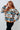 Woman wearing a patterned sweater against a white background