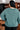 Person wearing a teal sweater in an indoor setting