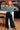 Woman wearing a teal sweater and black pants in an indoor setting