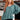 Woman wearing a teal sweater and black pants in an indoor setting