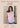Woman wearing a light pink sleeveless top with model measurements displayed below.