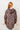 Person wearing a leopard print hoodie against a white wall