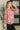 Woman wearing a colorful floral blouse in an indoor setting