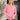 Woman wearing a pink long-sleeve top and white beanie indoors.