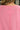 Close-up of a pink garment with a pocket, worn by a person.