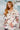 Woman wearing a patterned jacket with a blurred indoor background