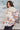 Woman wearing a patterned coat with a blurred indoor background