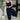 Woman wearing a navy jumpsuit with a white background
