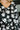Black top with white floral pattern worn by a person