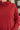 Red cowl-neck sweater worn by a person, with a blurred background