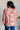 Person wearing a floral blouse with a white brick wall background